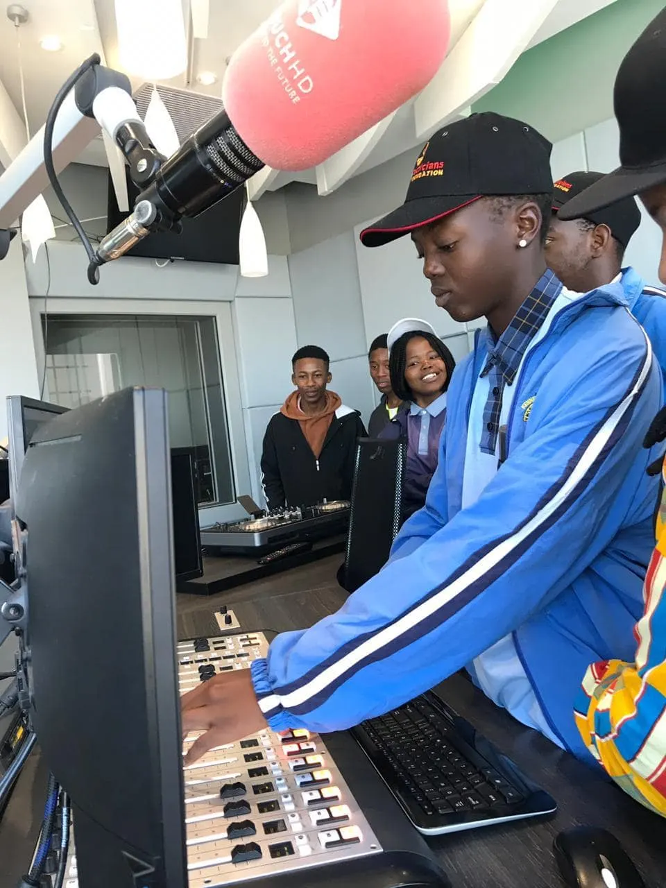 Learner working a radio mixing desk in a broadcast studio